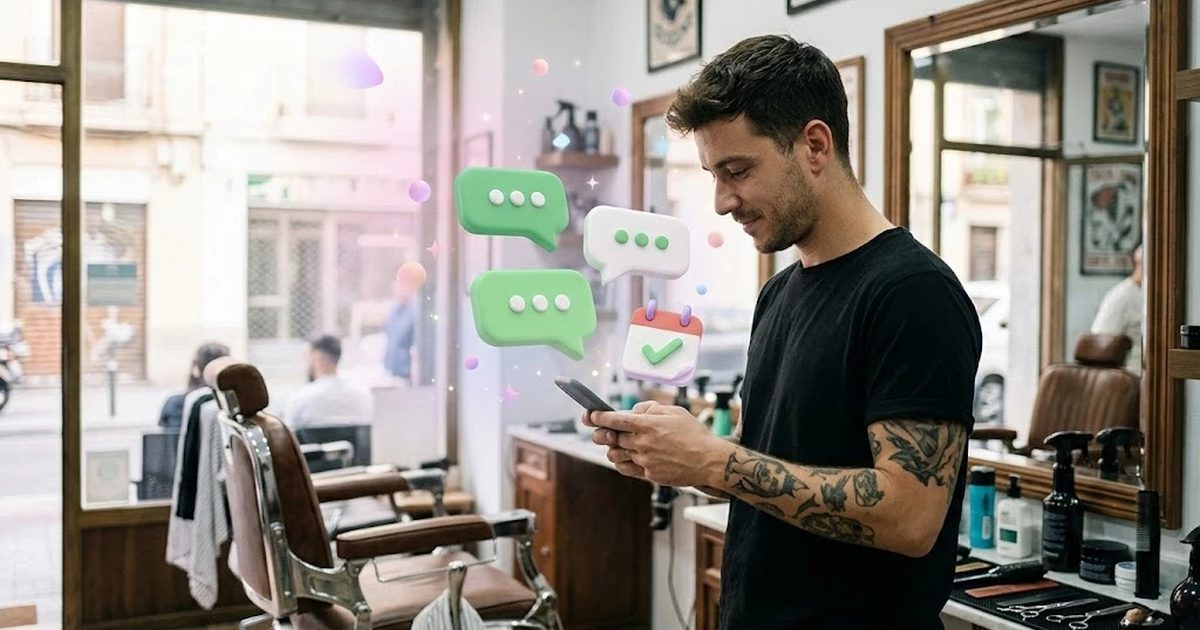 Peluquero de una barbería de barrio contestando mensajes de clientes por WhatsApp entre corte y corte